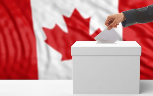 Person putting a ballot into a voting box.