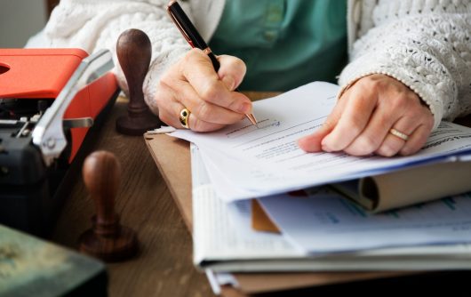 senior woman signing document