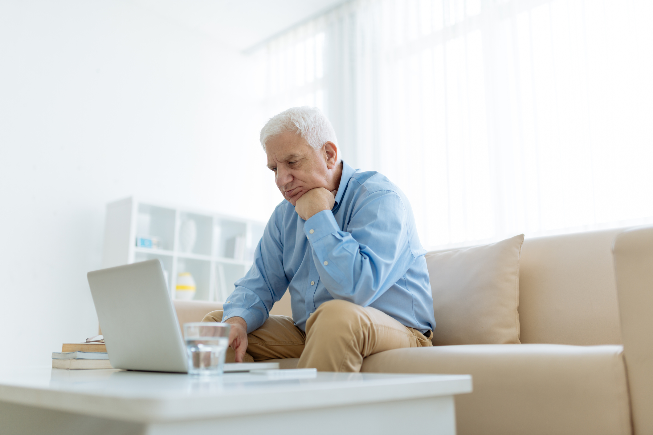 Homme lisant un ordinateur portable sur un canapé