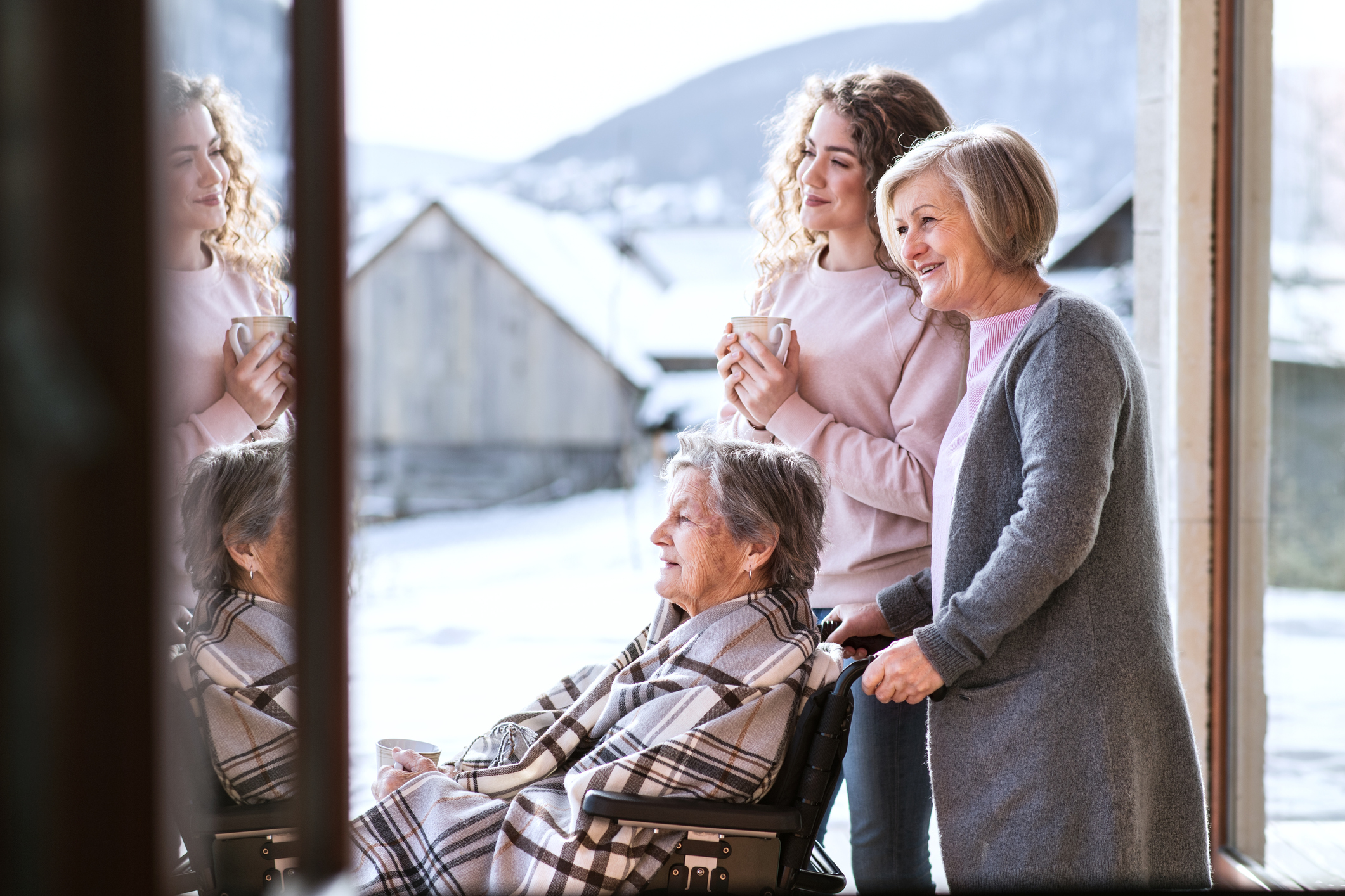 Grandmother, mother and daughter sitting on porch smiling