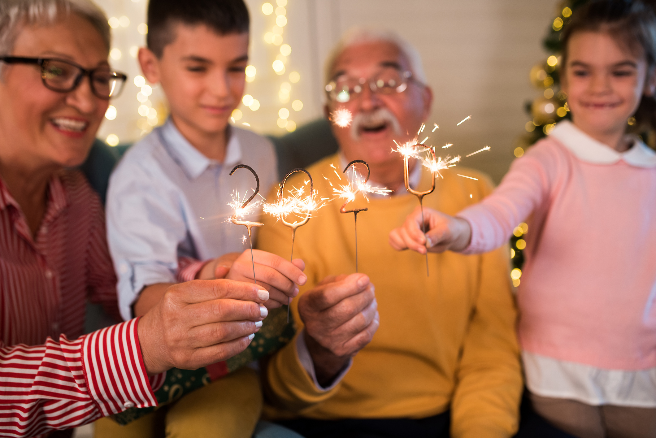 Seniors et petits-enfants avec des cierges magiques 2020