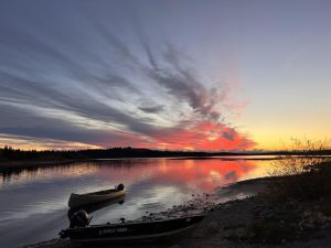 Sunset over river with canoe