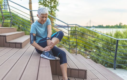 Senior woman athlete stretching before run