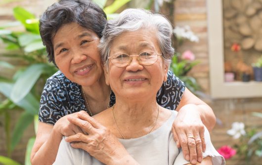 Two female senior friends embracing