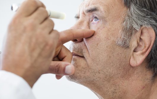 Docteur vérifiant les yeux de l'homme