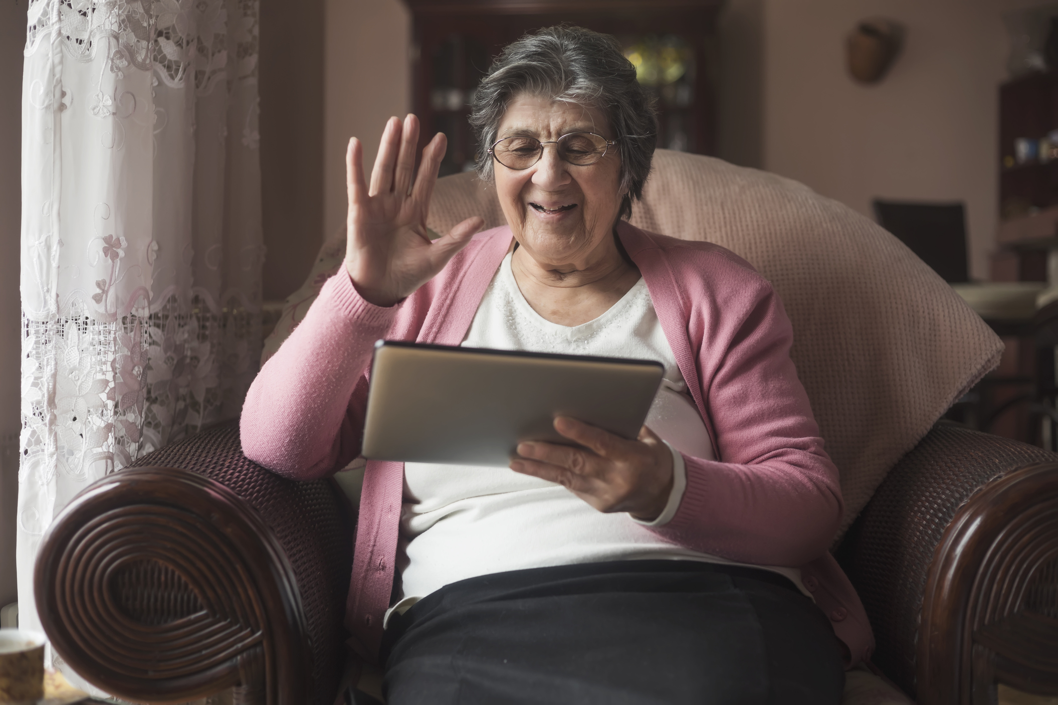 Femme âgée à la maison à l'aide d'iPad