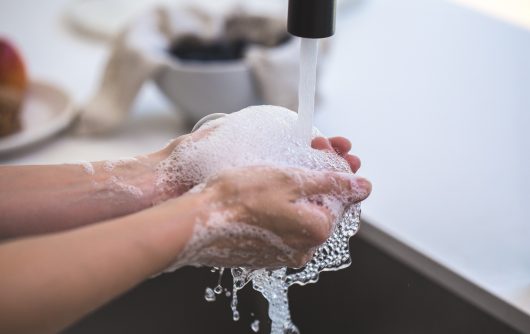 Person washing hands in sink