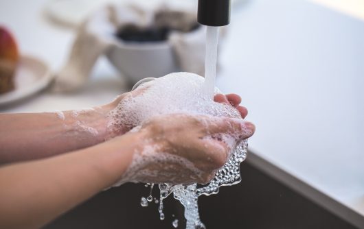 Personne se lavant les mains dans l'évier