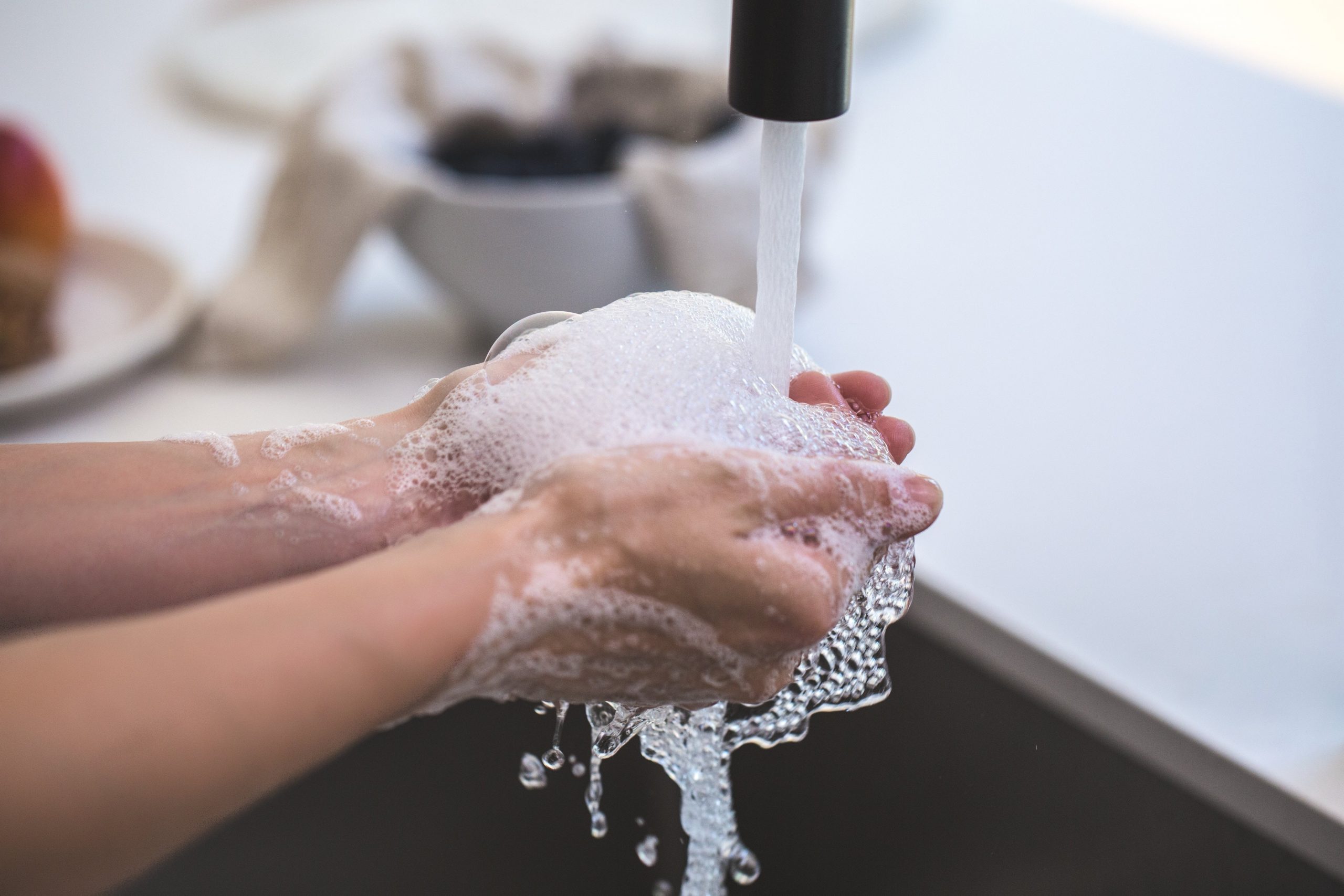 Personne se lavant les mains dans l'évier