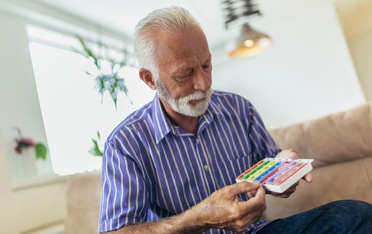 Senior man taking pills at home