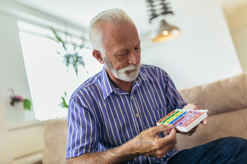 Senior man taking pills at home