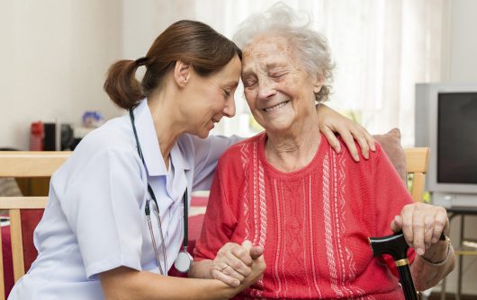 Caregiver embracing elderly woman