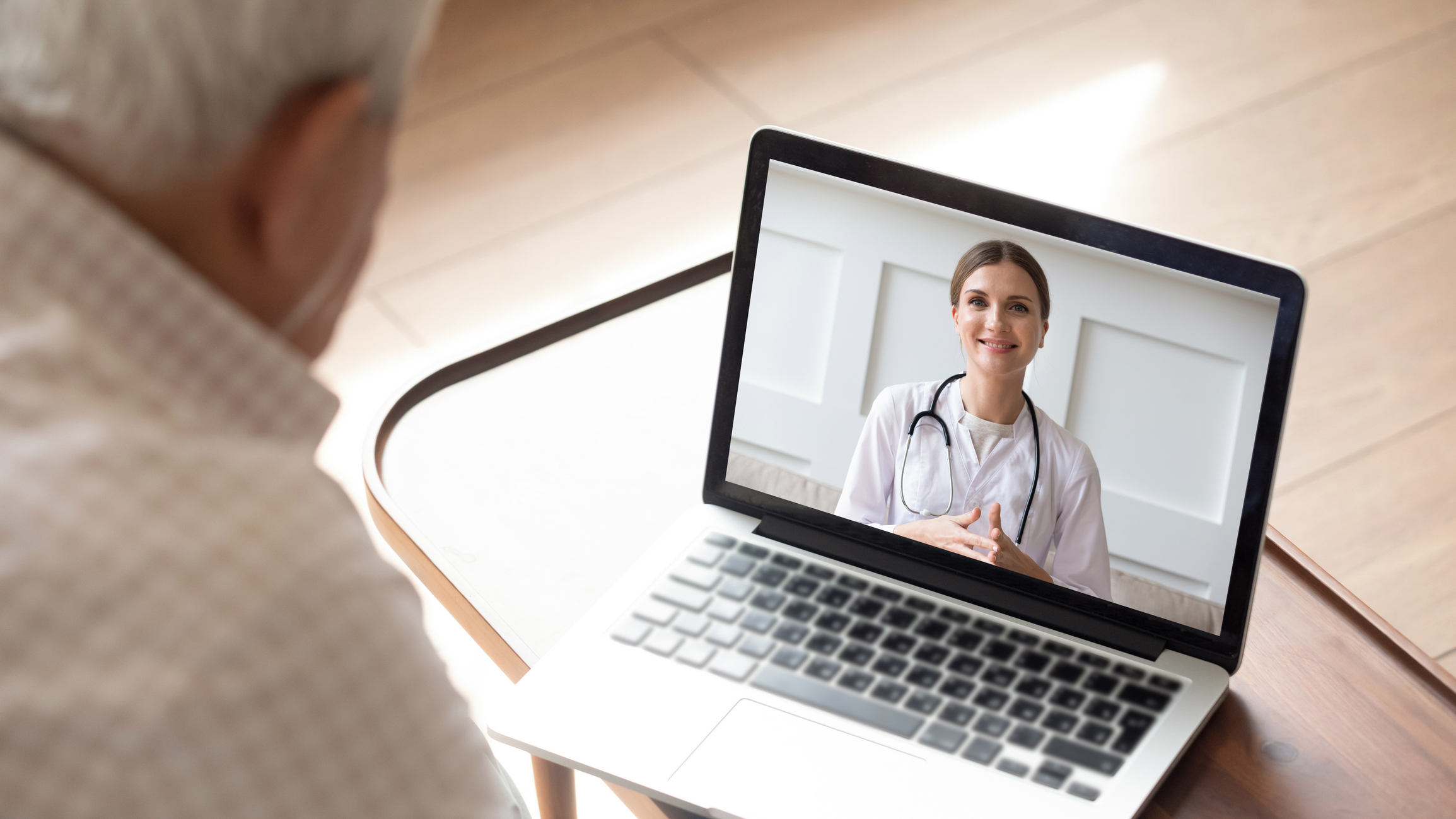 Elderly man receiving care from a doctor virtually through live video call