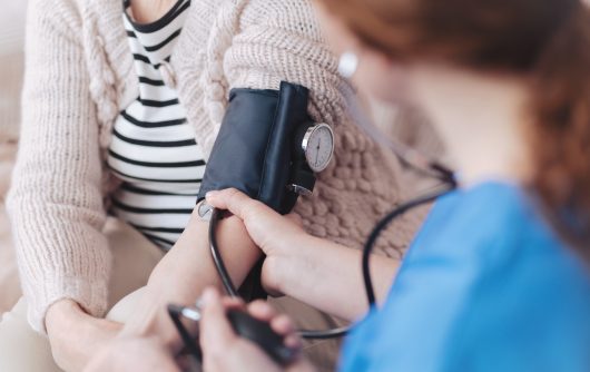 nurse taking woman's blood pressure