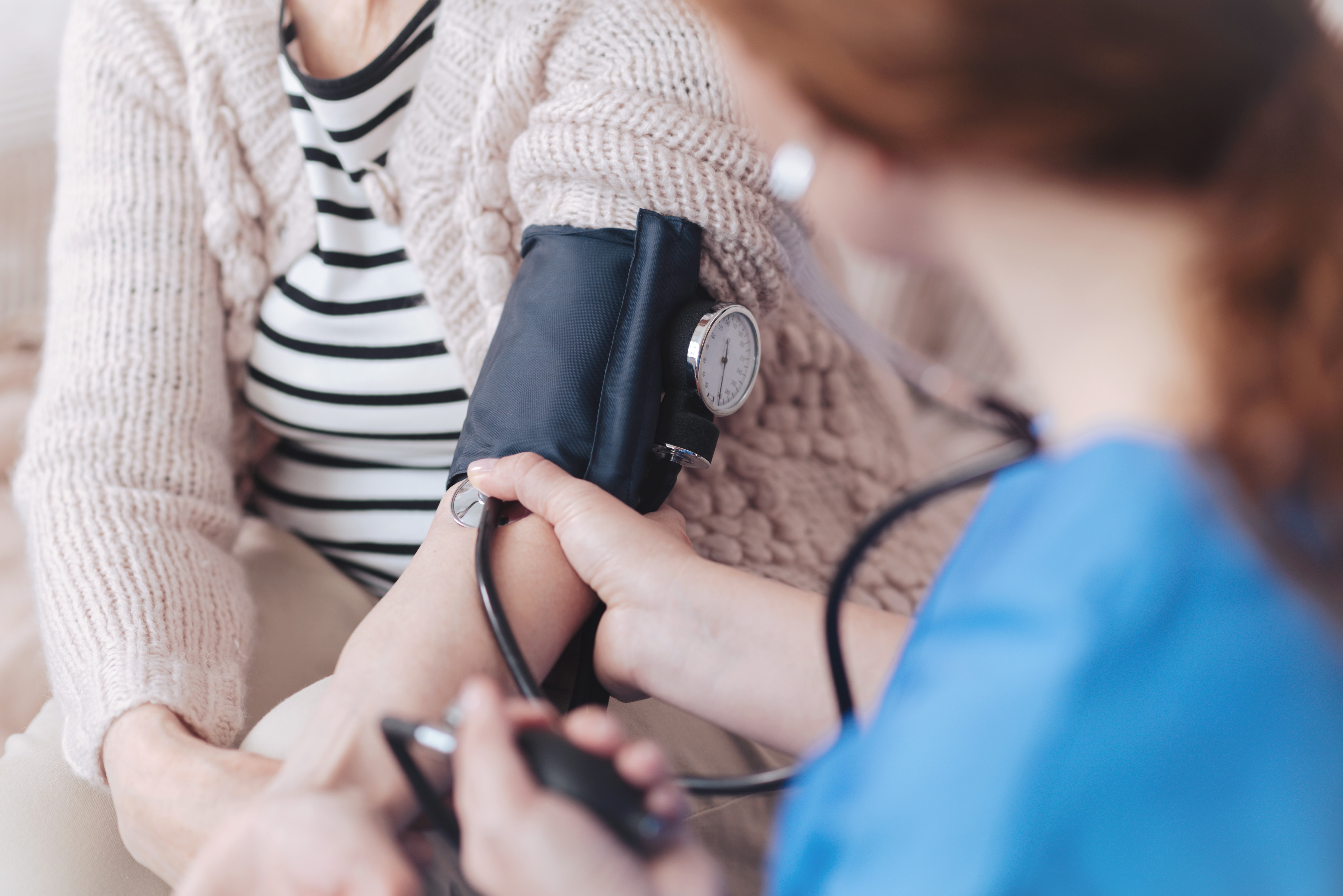 nurse taking woman's blood pressure