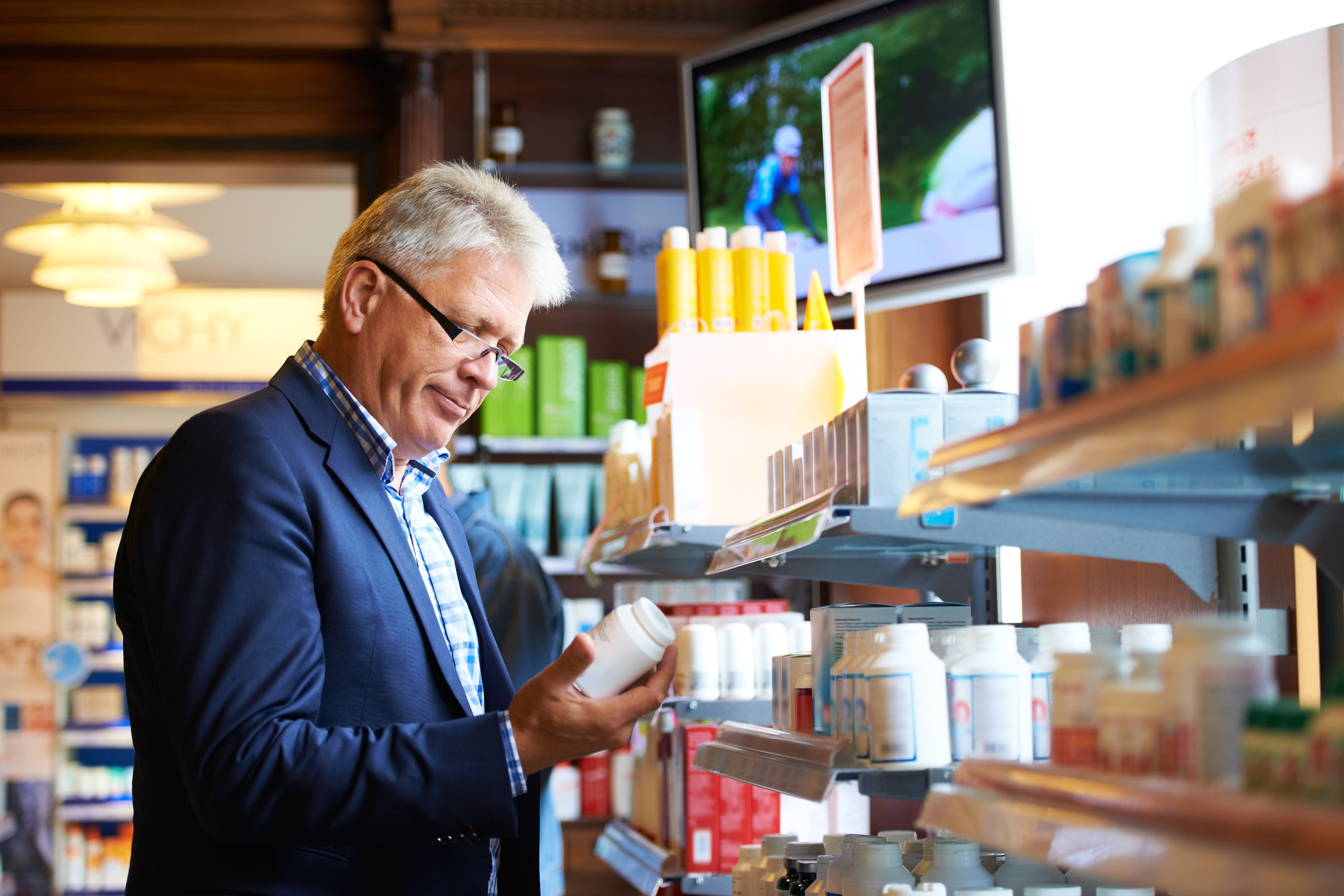 Homme adulte regardant des médicaments en pharmacie