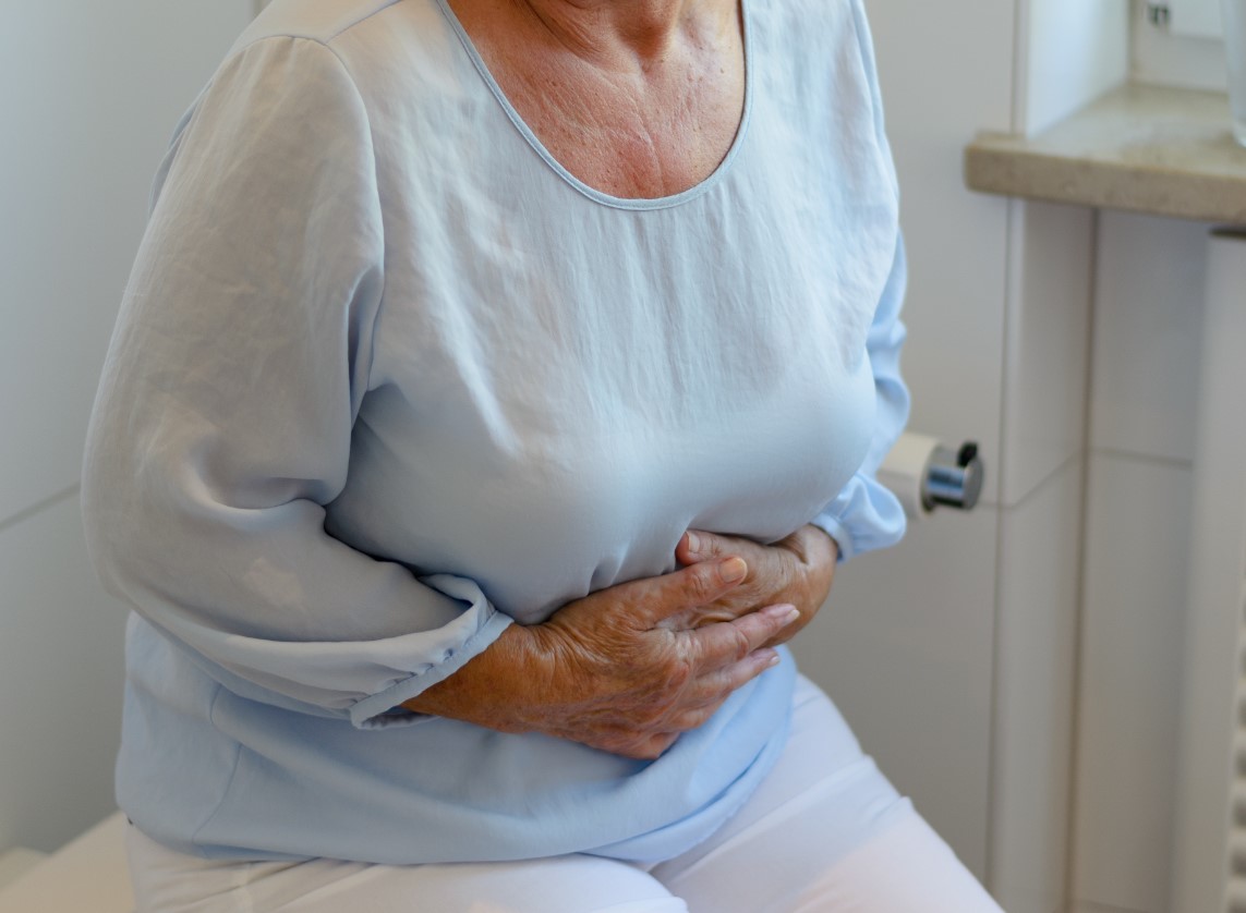 senior woman holding stomach in pain