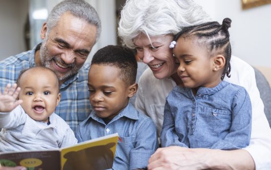 Grandparents and toddlers reading story book