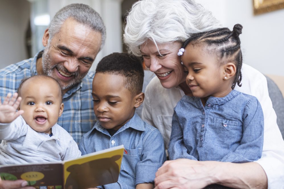 Grandparents and toddlers reading story book