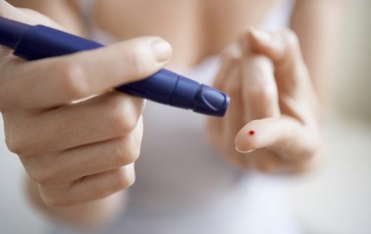 Woman testing diabetes on finger