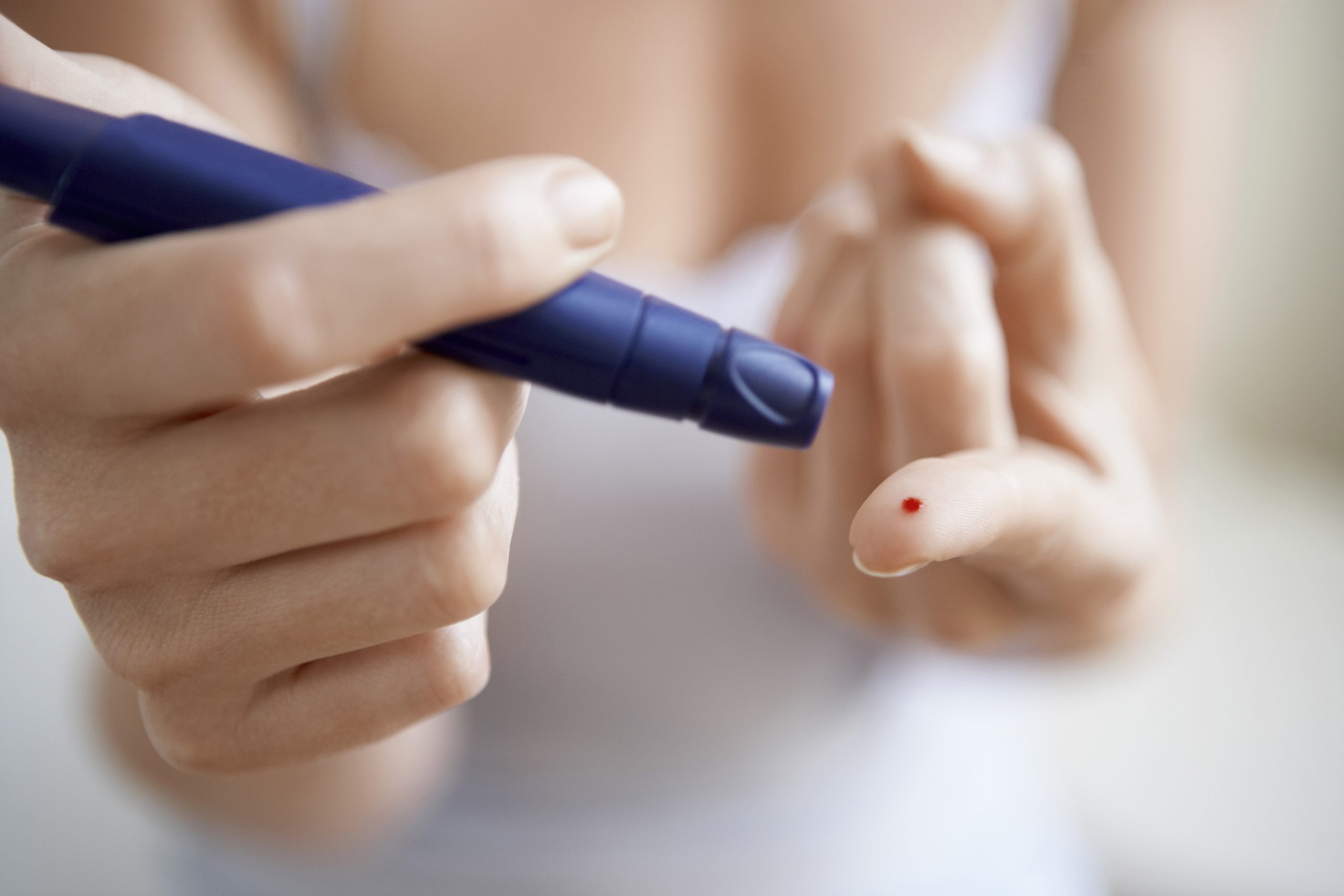 Woman testing diabetes on finger