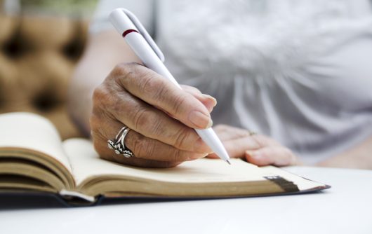 Senior woman writing in notebook