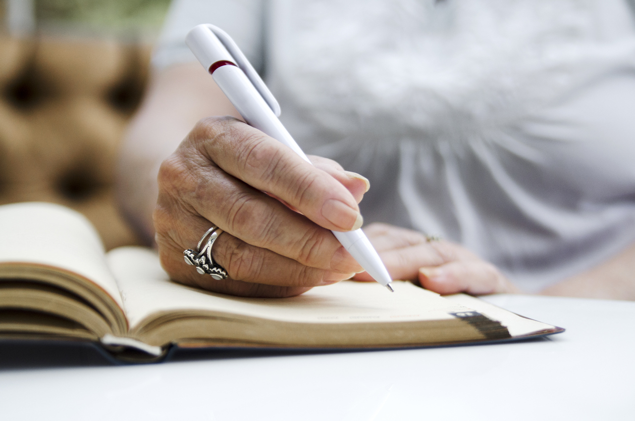 Senior woman writing in notebook