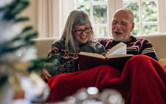 Adult couple happily reading book