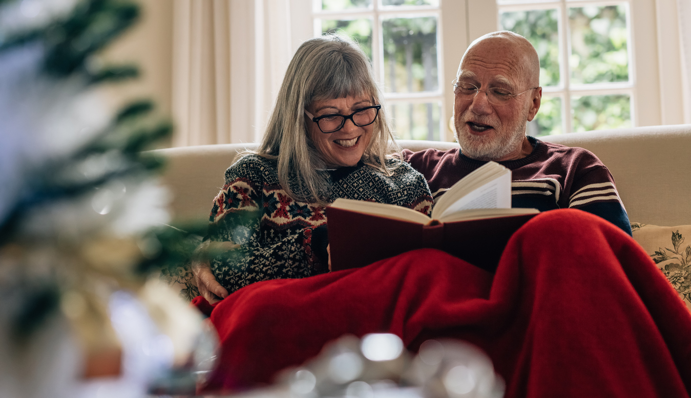 Adult couple happily reading book