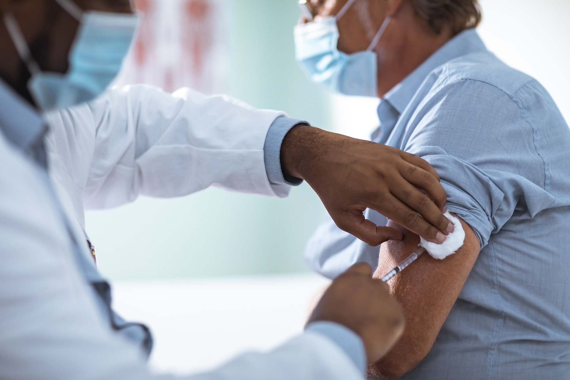 Doctor giving adult man a vaccine