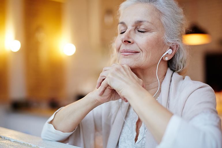 elderly woman listening to earbuds