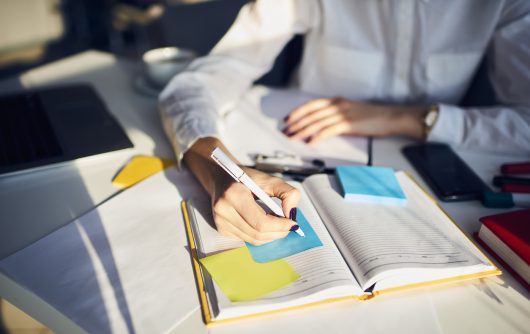 Professional woman writing on sticky note