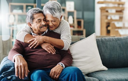 Cheerful elderly woman hugging her husband