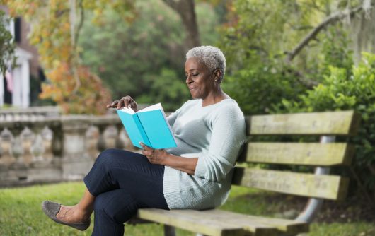 Senior black woman reading a book