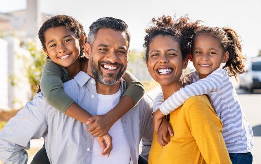 Multiethnic parents giving children piggyback ride