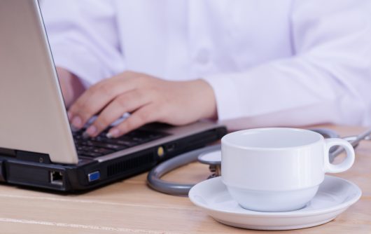 Medical doctor typing on laptop