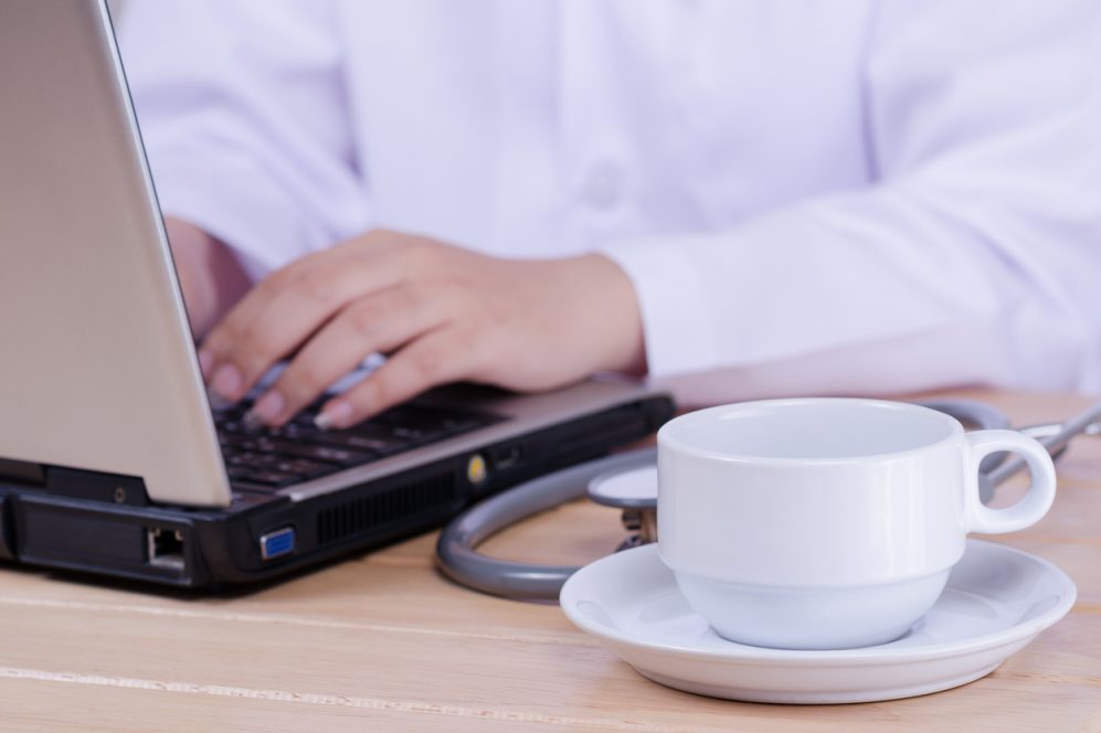 medical doctor typing on laptop