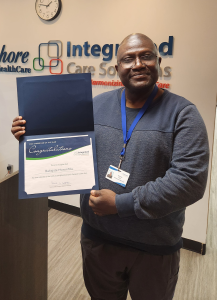 A Bayshore PSW holding a "Caregiver of the Year" Award.