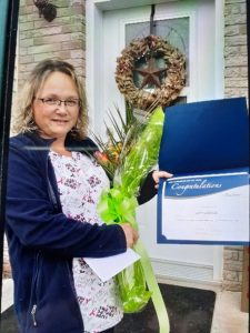 Woman holding award and flowers