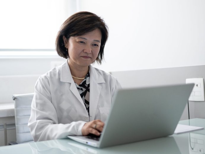 Médecin travaillant sur l'ordinateur portable dans une clinique médicale
