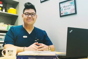 Homme en bleu souriant derrière un bureau