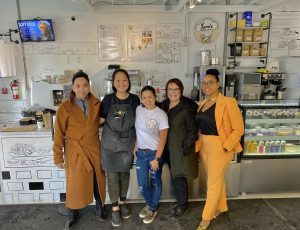 Group of people posing inside a bakery