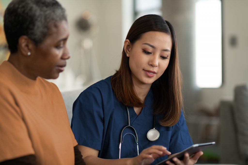 Nurse explaining the care plan to a senior client using a tablet device
