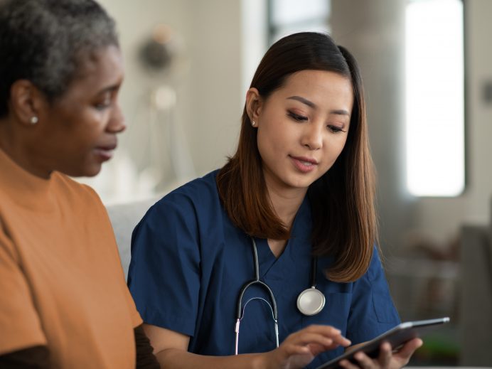 Nurse explaining the care plan to a senior client using a tablet device