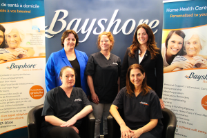 Group of 5 women posing in front of bayshore signage