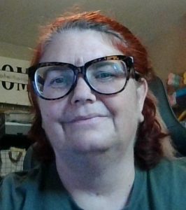 Woman smiling wearing glasses.