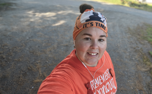 Femme en orange souriant à l'appareil photo