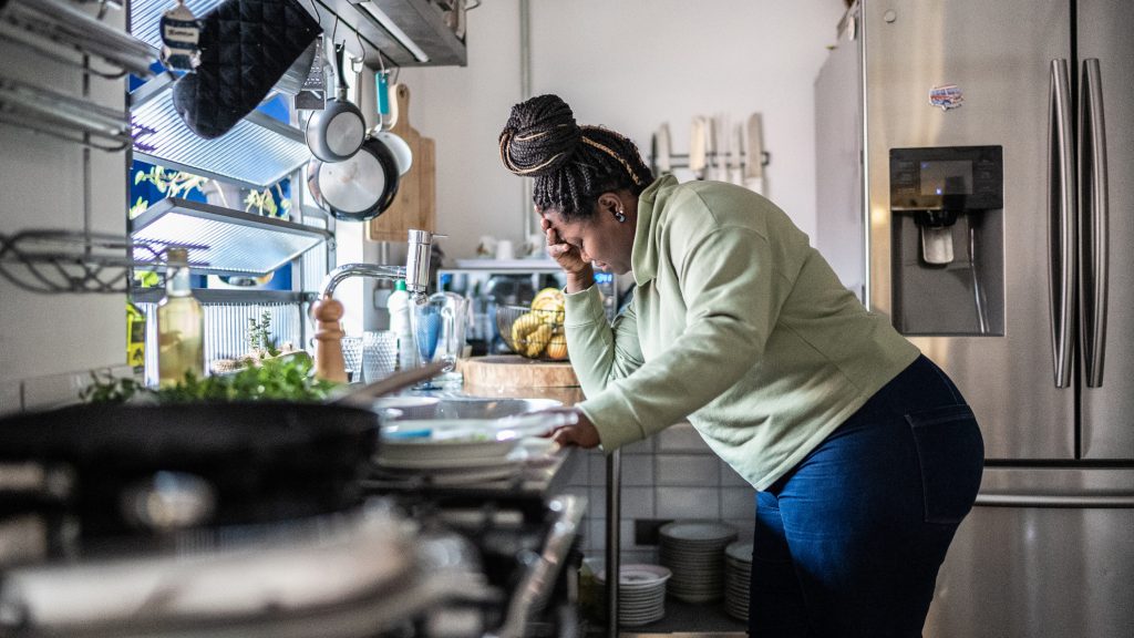 Sad mid adult woman in the kitchen at home