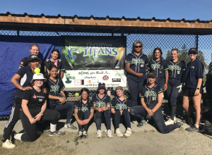 A softball team posing outside in uniform