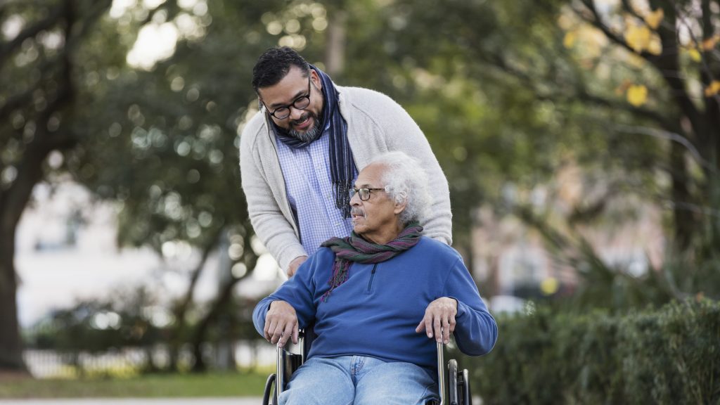Senior Hispanic man in wheelchair, with adult son
